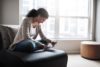 Woman looking at digital tablet credit card in hand