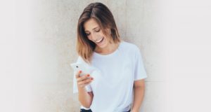 Woman laughing while looking at smart phone
