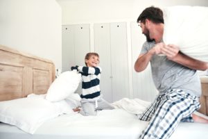 Man and boy in a pillow fight laughing