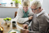 Older man and woman looking at tablet at table
