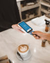 Person making a purchase using chip reader at cafe