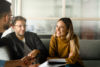 Woman and two men conversing and smiling