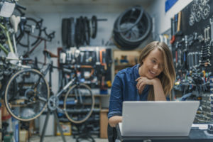 Woman on laptop in a cycling shop