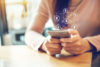 Woman using smart phone with graphic of dollar signs
