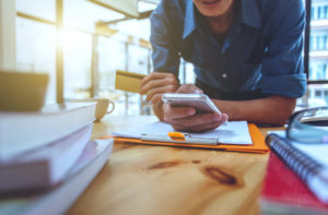 Man holding smart phone looking at clipboard