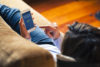 Man laying on couch mobile banking on smart phone