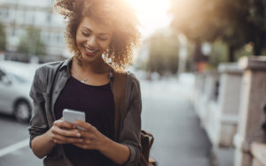 Woman smiling on her phone walking down street