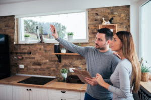 a couple stands in their kitchen envisioning their renovation ideas after getting all of their HELOC questions answered