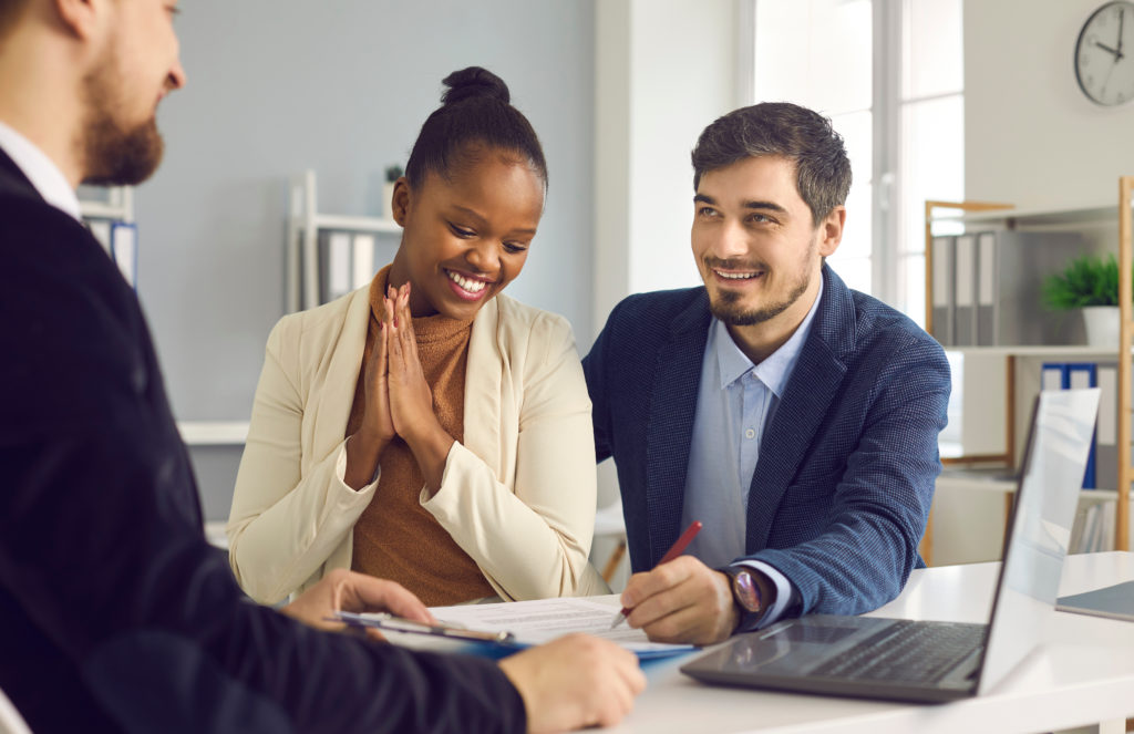 A couple meets with a credit union representative to discuss credit union personal loan requirements.