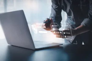 Man looking at a laptop with a holographic display of identity protection