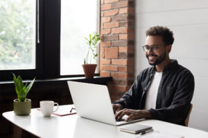 Young businessman working at home office, using laptop.