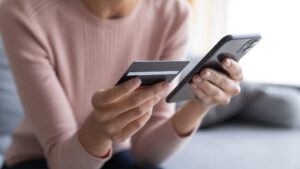 Close up woman holding a credit card and smart phone.