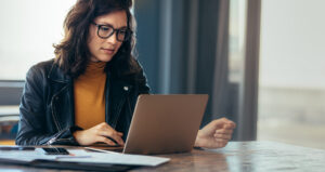 Serious woman working on laptop in an office.