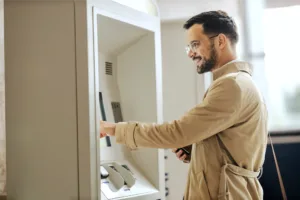 Man smiling using ATM