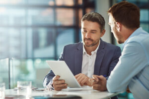 Two business men looking at papers on desk