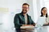 Business man and woman sitting at a desk smiling