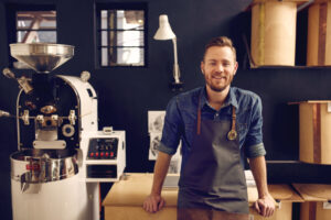 Man smiling standing in front of equipment in a shop.