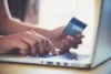 Person typing credit card information into computer.